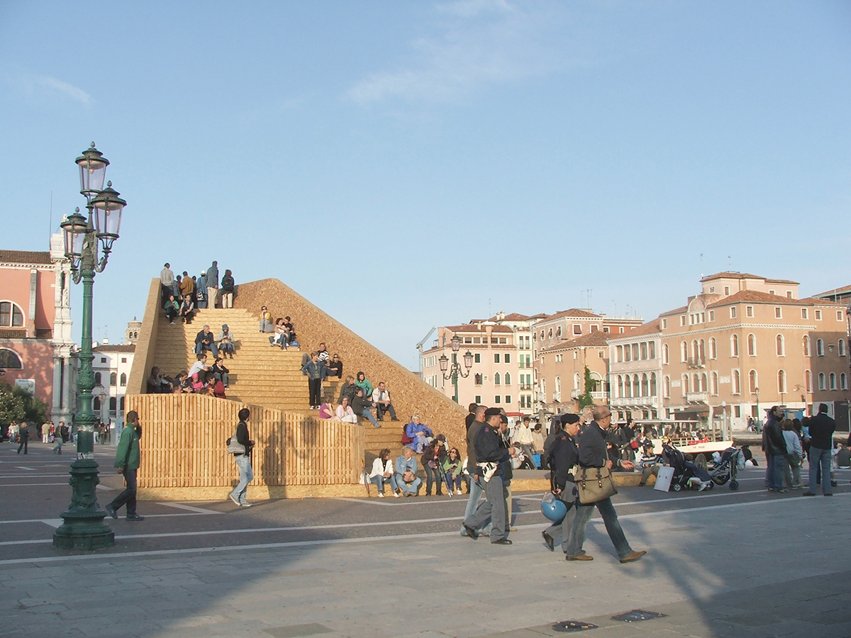 Large wooden structure with steps and people walking over