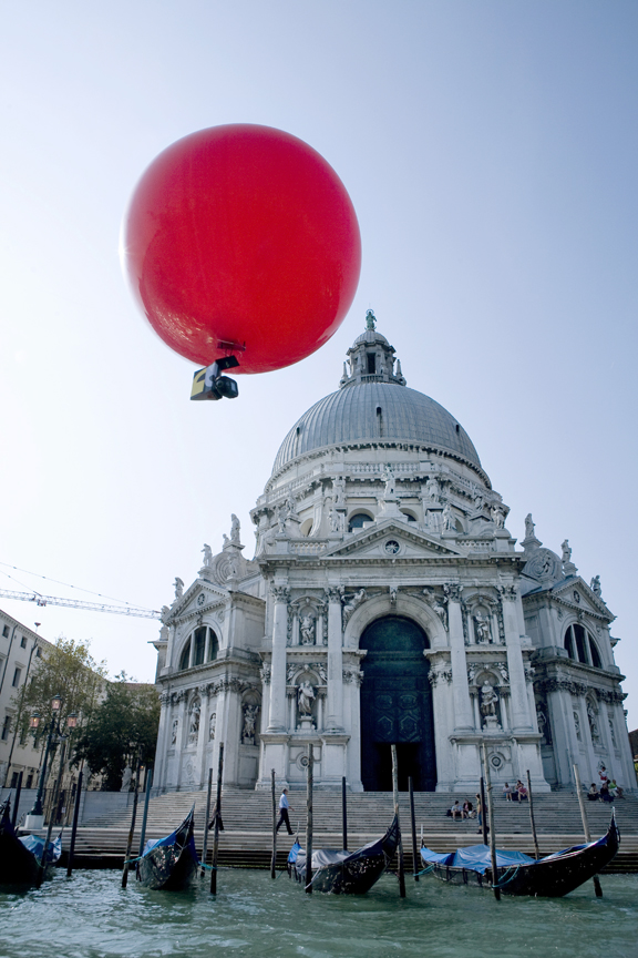 Photo of large red balloon in front of an impressive traditional Italian building