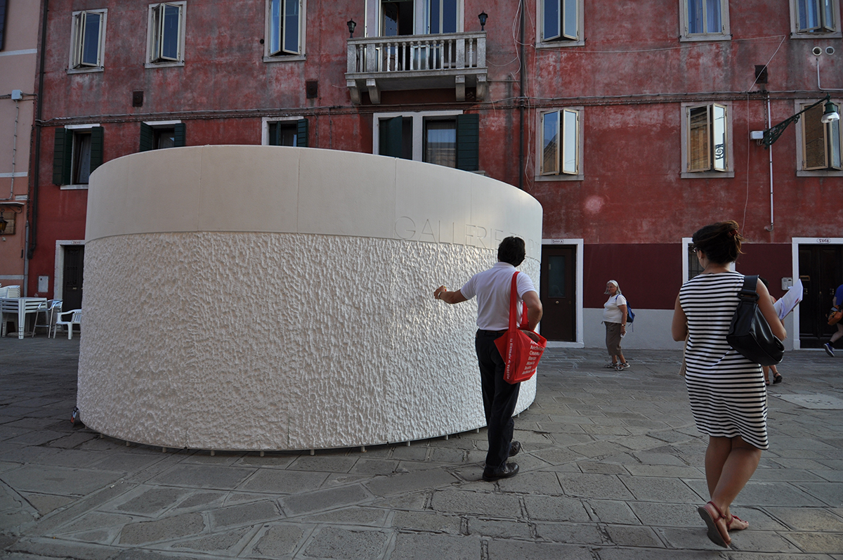 Large white stone structure with a person touching it