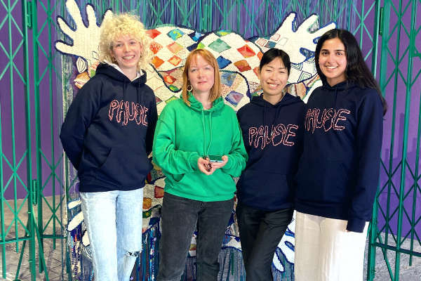 Leya McKay, PDP participant supported by Gray’s School of Art Aberdeen, Louise Briggs, Production Manager, Joanne Lee, PDP participant supported by Scottish Contemporary Art Network, and Aqsa Arif, PDP participant supported by British Council Scotland and Scotland + Venice, all standing in front of the tapestry created by Alberta for her presentation at Scotland + Venice